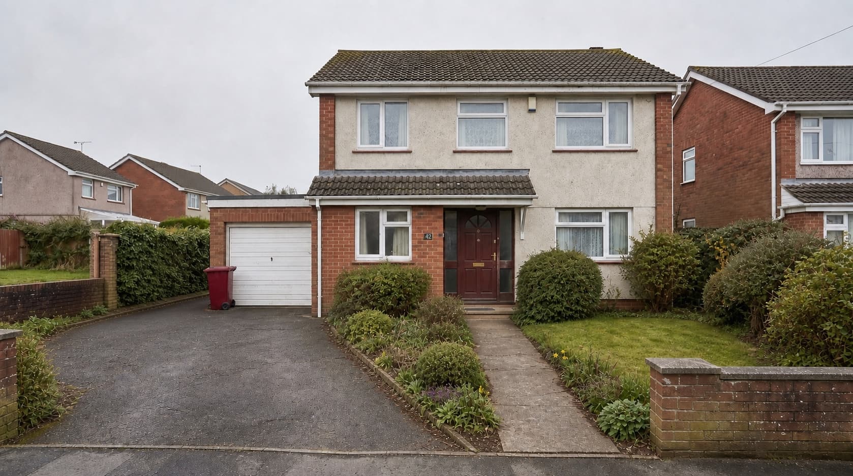 A dated detached house with pebbledash and a mature front garden, before renovation